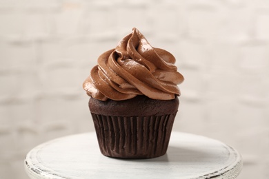 Delicious chocolate cupcake with cream on white table, closeup