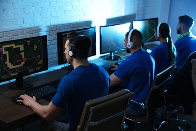 Young people playing video games on computers indoors. Esports tournament