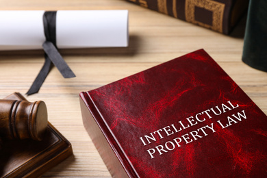Intellectual Property law book and judge's gavel on wooden table