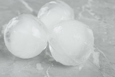 Frozen ice balls on grey marble table, closeup