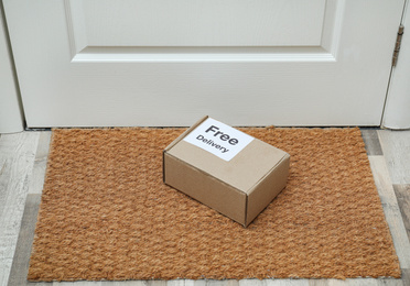 Parcel with sticker Free Delivery on rug indoors. Courier service