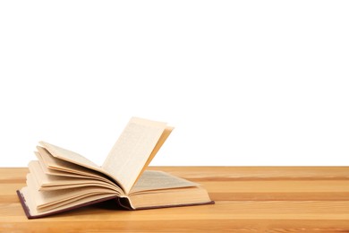 Open book on wooden table against white background. Library material