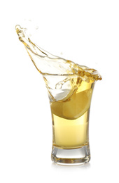 Splashing Mexican Tequila in shot glass with lime slice isolated on white