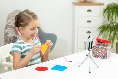 Cute little blogger with handcrafting recording video at home