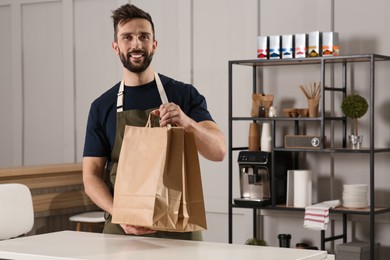 Photo of Worker with paper bags at counter in cafe, space for text