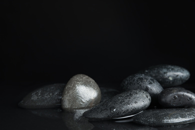 Photo of Stones in water on black background, space for text. Zen lifestyle