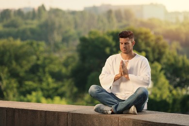 Man meditating outdoors on summer day. Space for text