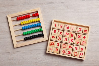 Photo of Math game with numbers and colorful toy abacus on white wooden table, flat lay