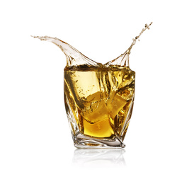 Whiskey splashing in glass on white background