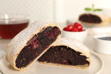 Photo of Delicious strudel with cherries and poppy seeds on plate, closeup