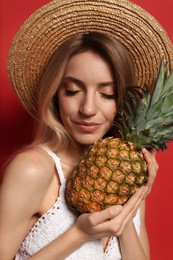 Photo of Young woman with fresh pineapple on red background, closeup. Exotic fruit