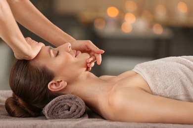 Beautiful young woman enjoying massage in spa salon