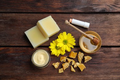 Flat lay composition with beeswax and cosmetic products on wooden table