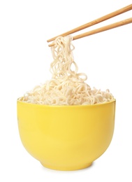 Photo of Chopsticks with tasty instant noodles over bowl isolated on white