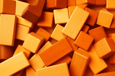 Orange wooden construction set as background, top view