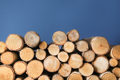 Cut firewood on blue background. Heating in winter