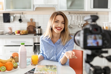 Food blogger recording video on camera in kitchen