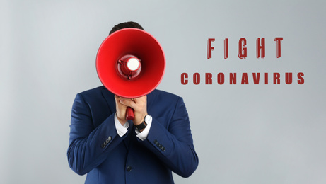 Man in suit with megaphone on grey background. Fighting with coronavirus