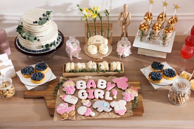 Baby shower party. Different delicious treats on wooden table indoors, above view
