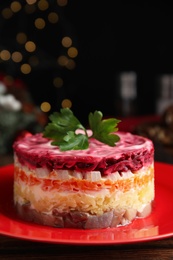 Photo of Herring under fur coat on red plate, space for text. Traditional russian salad