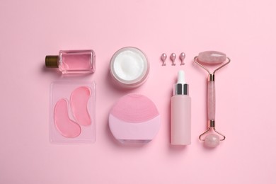 Flat lay composition with skin care products and accessories on pink background