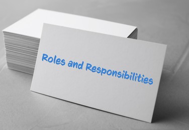Sheet of paper with text Roles and Responsibilities on grey stone table