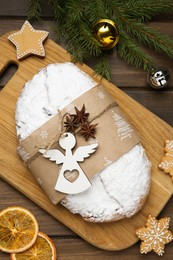 Photo of Decorated traditional Christmas Stollen with festive decor on wooden table, flat lay