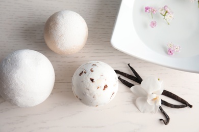 Photo of Flat lay composition with bath bombs and vanilla pods on white wooden background