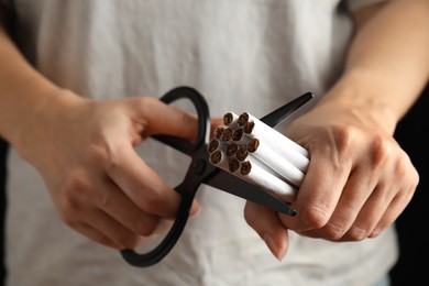 Woman cutting cigarettes, closeup. Quitting smoking concept