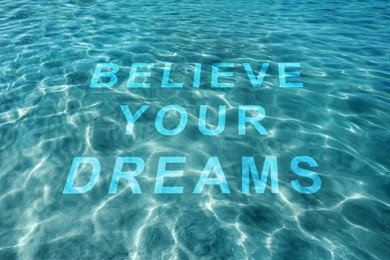 Motivational quote Believe Your Dreams, view on text through ocean water