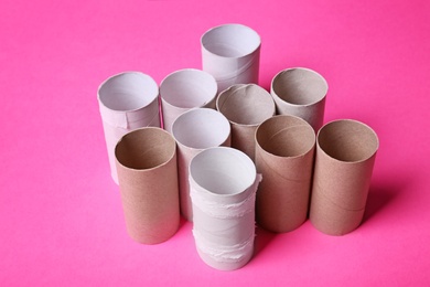 Empty toilet paper rolls on color background