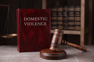 Domestic violence law and gavel on grey marble table