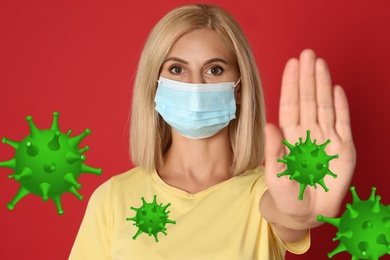 Stop Covid-19 outbreak. Woman wearing medical mask surrounded by virus on red background