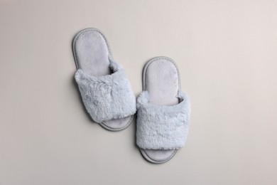 Pair of soft slippers on light grey background, top view