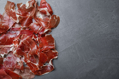 Tasty prosciutto on grey table, flat lay. Space for text