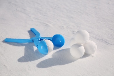 Snowballs and light blue plastic tool outdoors on winter day