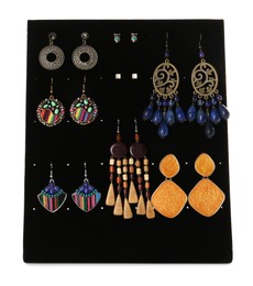 Display stand with different earrings on white background