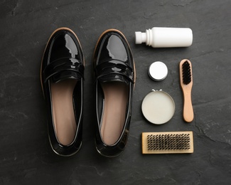 Flat lay composition with shoe care accessories and footwear on black background