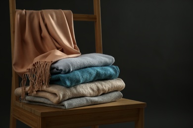 Photo of Stack of cashmere clothes on wooden chair