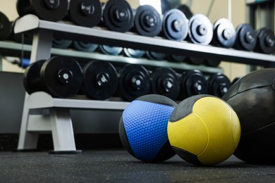 Medicine balls on floor in gym, space for text