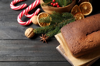 Delicious gingerbread cake and Christmas items on black wooden table, above view