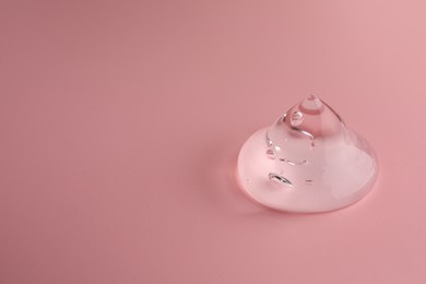 Sample of transparent gel on pink background, space for text