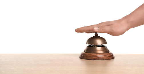Man ringing hotel service bell at wooden table