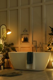Stylish bathroom interior with houseplants and string lights. Home design