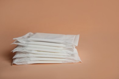 Menstrual pads on pale orange background. Gynecological care