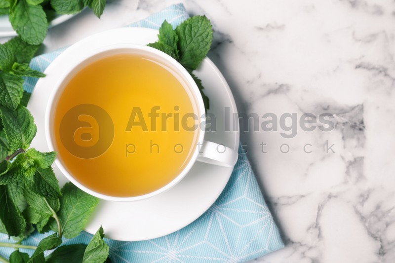 Fresh tea with mint on white marble table, flat lay