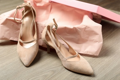 Pair of beautiful shoes and box on wooden background