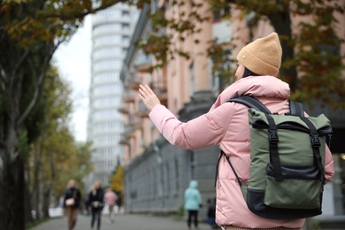 Young tourist with travel backpack in city on vacation. Space for text