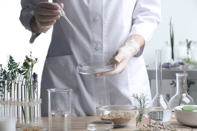 Scientist developing herbal cosmetic product in laboratory, closeup