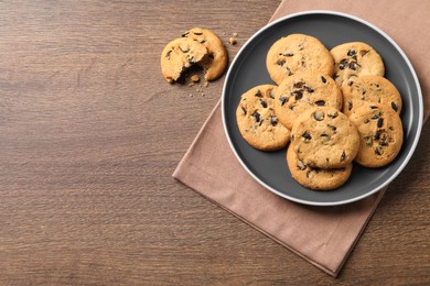 Delicious chocolate chip cookies on wooden table, flat lay. Space for text